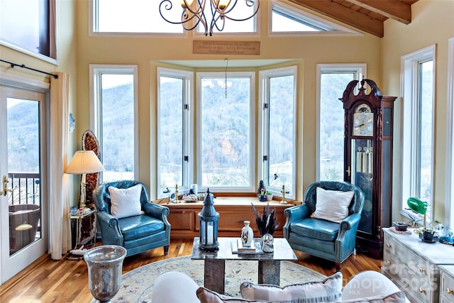 sunroom with vaulted ceiling with beams, wood ceiling, and a chandelier