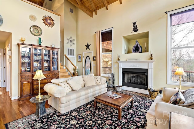 living room featuring beam ceiling, high vaulted ceiling, hardwood / wood-style flooring, and wood ceiling