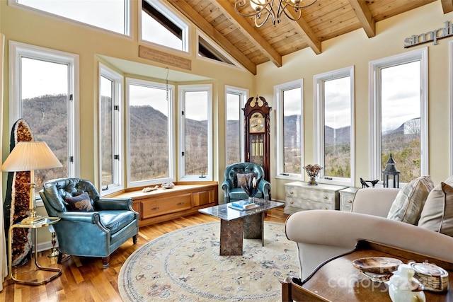 sunroom with plenty of natural light, a mountain view, and wooden ceiling