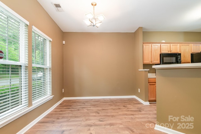 7117 Flying Scotsman Dr, Charlotte, NC 28213 - kitchen with black appliances, light wood finished floors, light brown cabinetry, and a chandelier