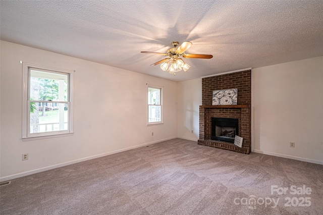 unfurnished living room with ceiling fan, carpet flooring, a textured ceiling, and a fireplace