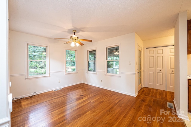 spare room featuring ceiling fan, dark hardwood / wood-style floors, and a textured ceiling