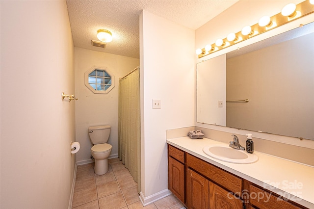 bathroom featuring vanity, tile patterned floors, a textured ceiling, and toilet