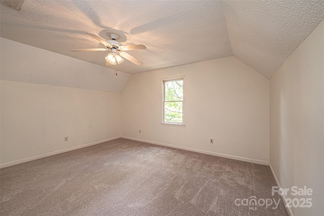 bonus room with ceiling fan, carpet floors, vaulted ceiling, and a textured ceiling