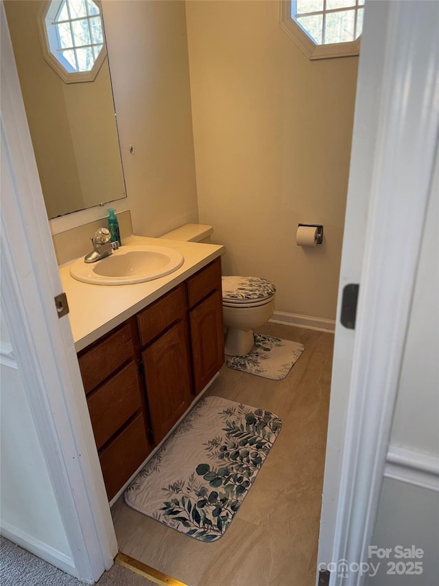 bathroom featuring vanity, plenty of natural light, and toilet