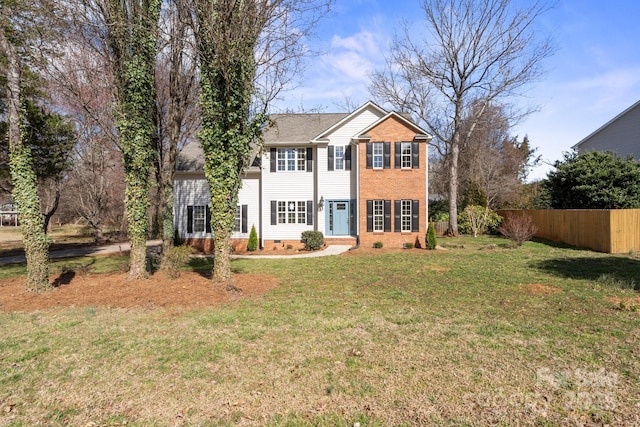 colonial inspired home with brick siding, crawl space, a front lawn, and fence