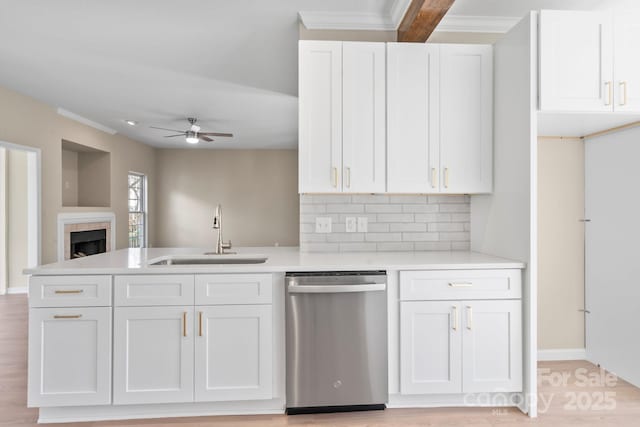 kitchen with white cabinetry, ceiling fan, a sink, light countertops, and stainless steel dishwasher