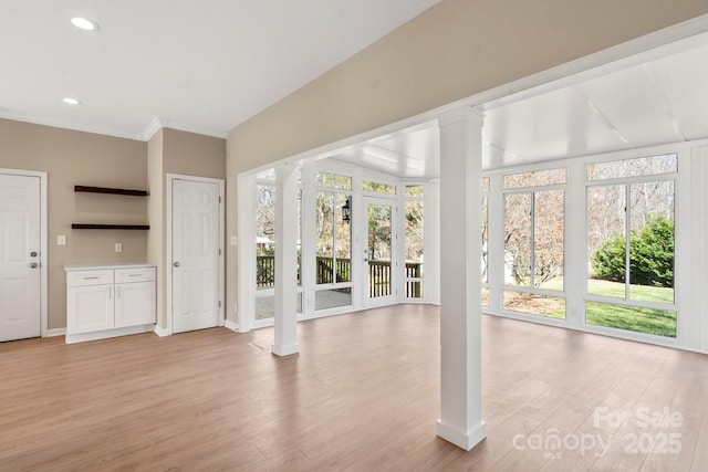 interior space featuring recessed lighting, light wood-style flooring, and decorative columns