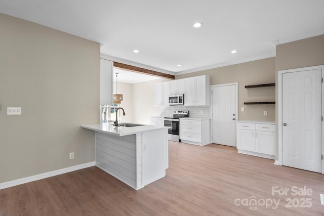 kitchen featuring a sink, a peninsula, white cabinets, and stainless steel appliances