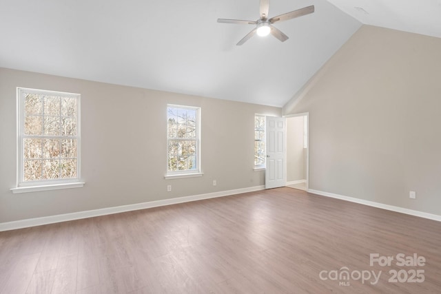 unfurnished room featuring plenty of natural light, wood finished floors, baseboards, and ceiling fan