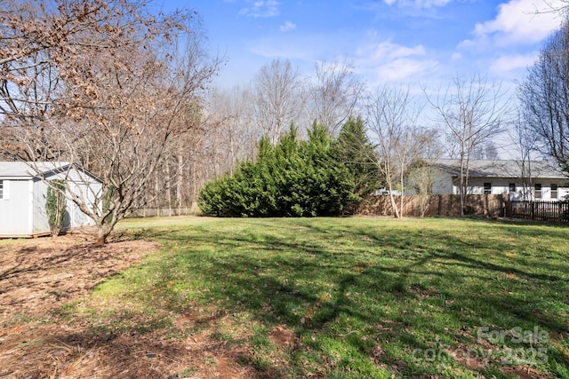 view of yard featuring an outdoor structure, a storage unit, and fence