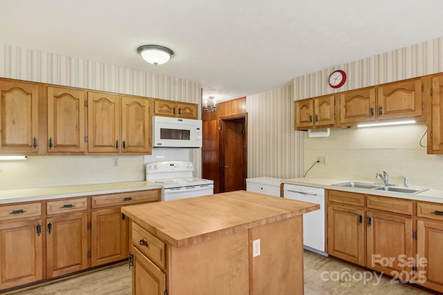 kitchen featuring a kitchen island, sink, wooden counters, and white appliances