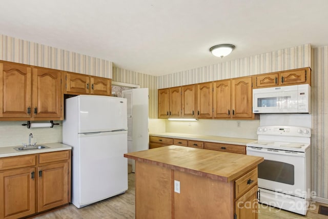 kitchen with sink, wooden counters, a kitchen island, white appliances, and light hardwood / wood-style floors