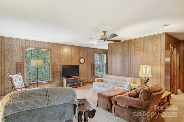 carpeted living room featuring plenty of natural light and wooden walls