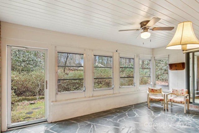 unfurnished sunroom with wood ceiling, ceiling fan, and a healthy amount of sunlight