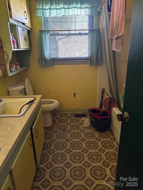 full bathroom with shower / tub combo with curtain, vanity, toilet, and tile patterned flooring