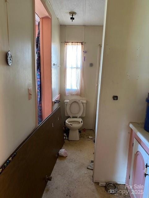 bathroom with a textured ceiling and toilet