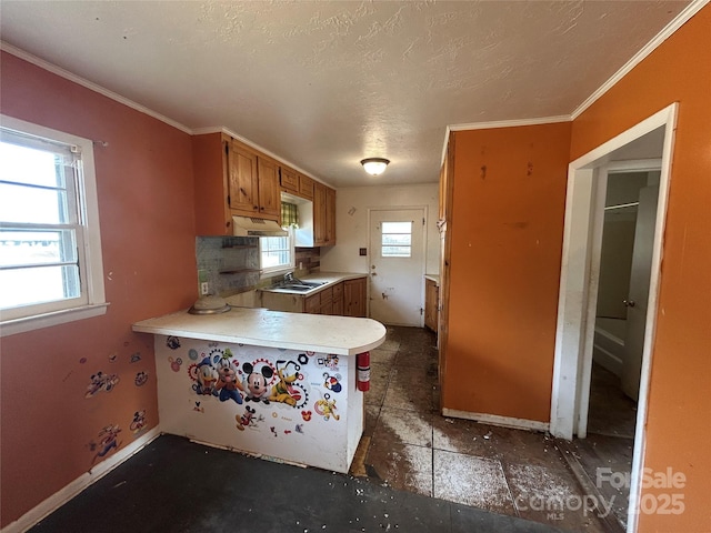 kitchen featuring crown molding, kitchen peninsula, and a textured ceiling