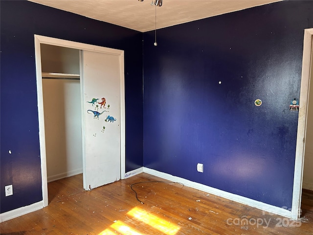 unfurnished bedroom with wood-type flooring and a closet