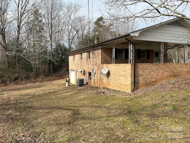 view of side of home with a yard and central AC unit