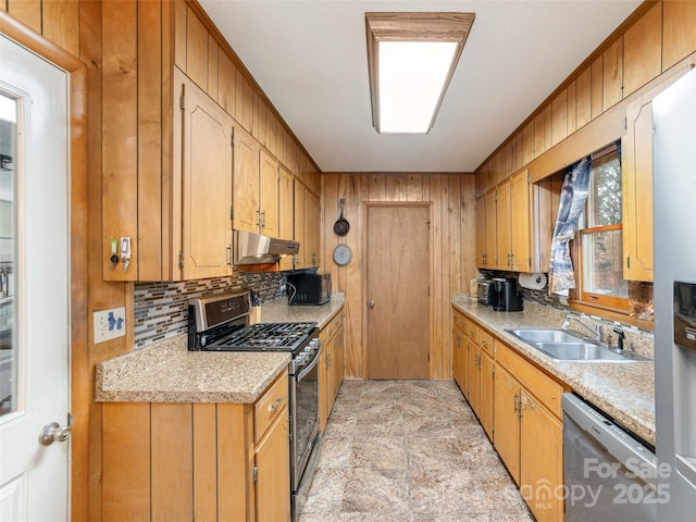 kitchen with appliances with stainless steel finishes, sink, and decorative backsplash