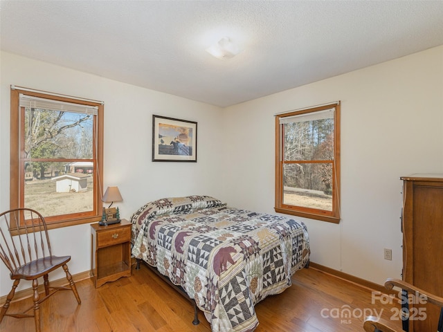 bedroom featuring a textured ceiling and light hardwood / wood-style floors