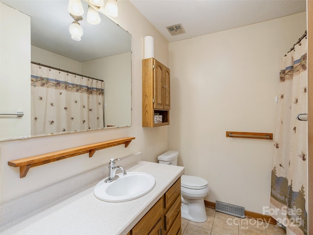 bathroom featuring tile patterned flooring, vanity, and toilet