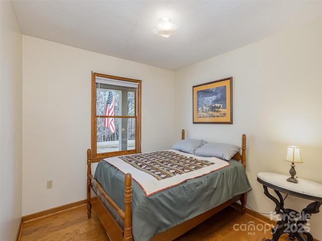 bedroom featuring light hardwood / wood-style flooring and a textured ceiling