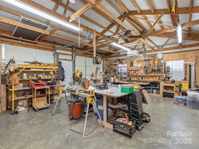 garage with a workshop area, an AC wall unit, and ceiling fan