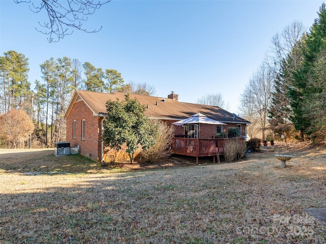 rear view of property with a yard and a deck