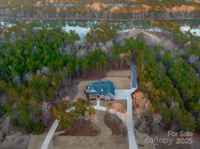 drone / aerial view featuring a water view and a forest view