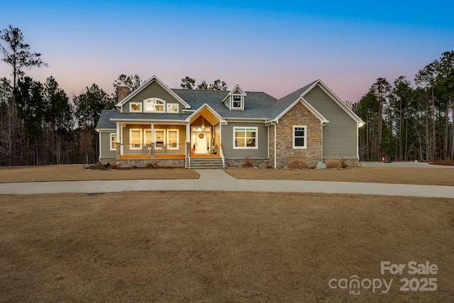 craftsman-style home featuring a porch and a lawn