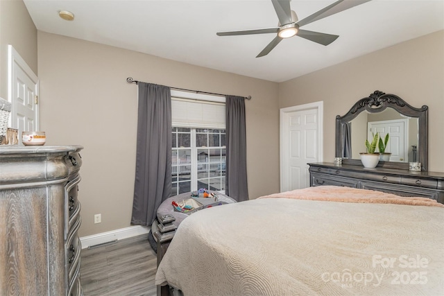 bedroom with dark hardwood / wood-style floors and ceiling fan