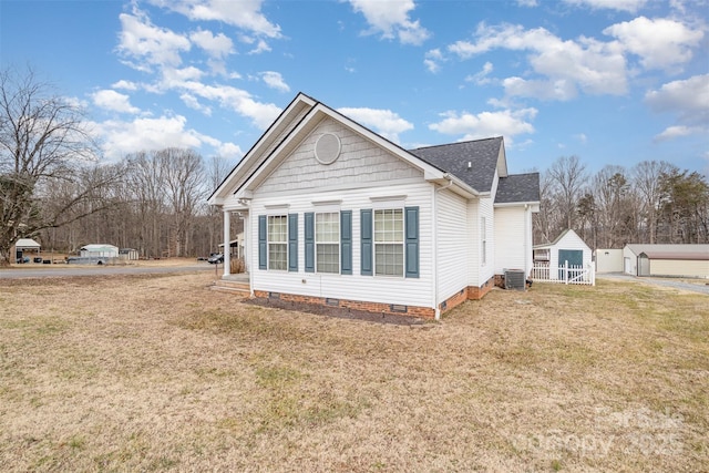 view of side of property with a storage shed, central AC unit, and a lawn