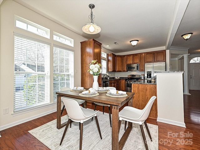 dining room with ornate columns and dark hardwood / wood-style flooring