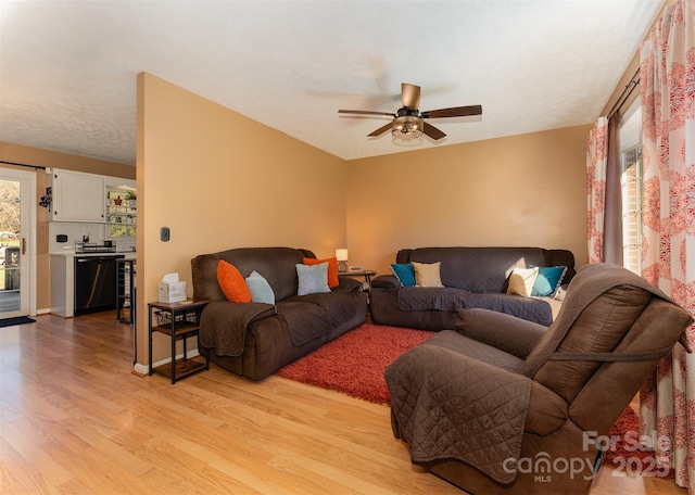 living room with ceiling fan and light wood-type flooring