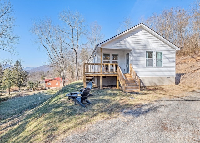 view of front of property featuring a mountain view, covered porch, and a front yard