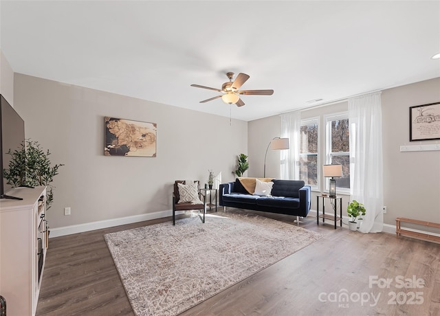 living area with dark hardwood / wood-style floors and ceiling fan