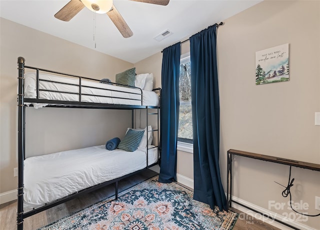 bedroom featuring multiple windows, wood-type flooring, and ceiling fan