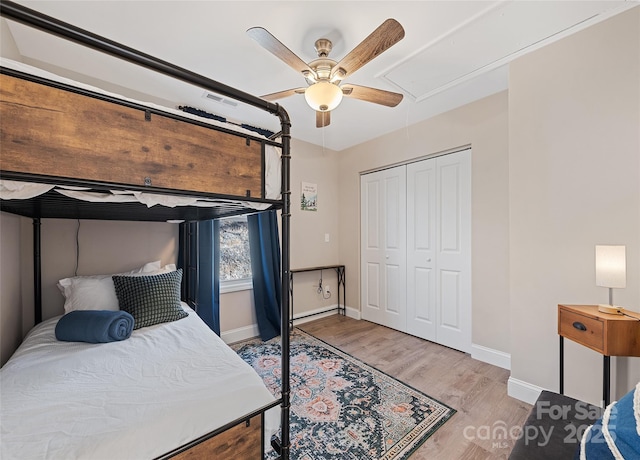 bedroom with light hardwood / wood-style flooring, a closet, and ceiling fan