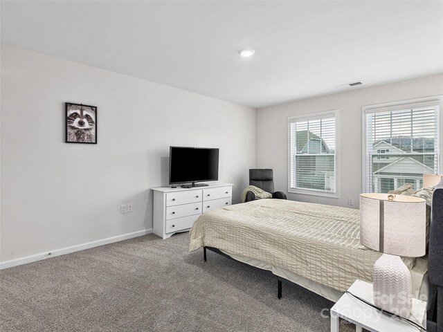 carpeted bedroom with visible vents and baseboards