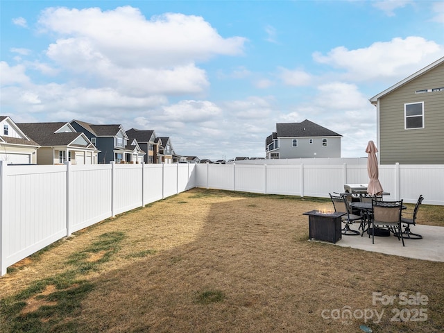 view of yard with a patio, a fenced backyard, and a residential view