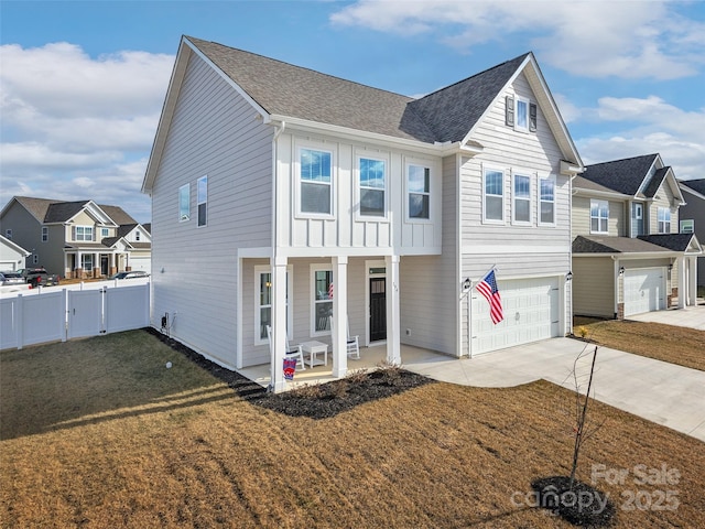 view of front of house with driveway, a residential view, fence, board and batten siding, and a front yard