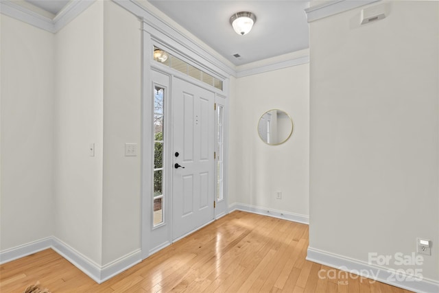 entrance foyer with ornamental molding and hardwood / wood-style floors