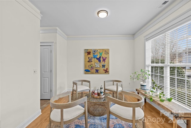 sitting room with ornamental molding and light wood-type flooring