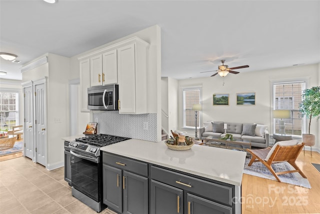 kitchen featuring appliances with stainless steel finishes, tasteful backsplash, white cabinetry, gray cabinetry, and ceiling fan