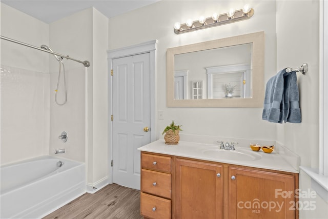 bathroom with washtub / shower combination, vanity, and hardwood / wood-style floors