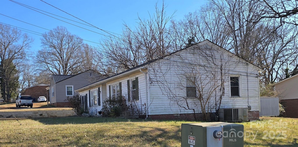 view of home's exterior with a lawn and central air condition unit