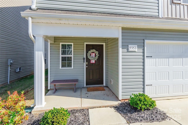 entrance to property featuring a garage and covered porch