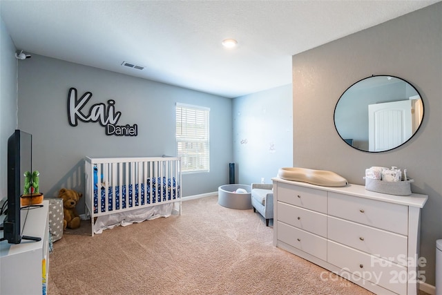 bedroom with light carpet and a nursery area